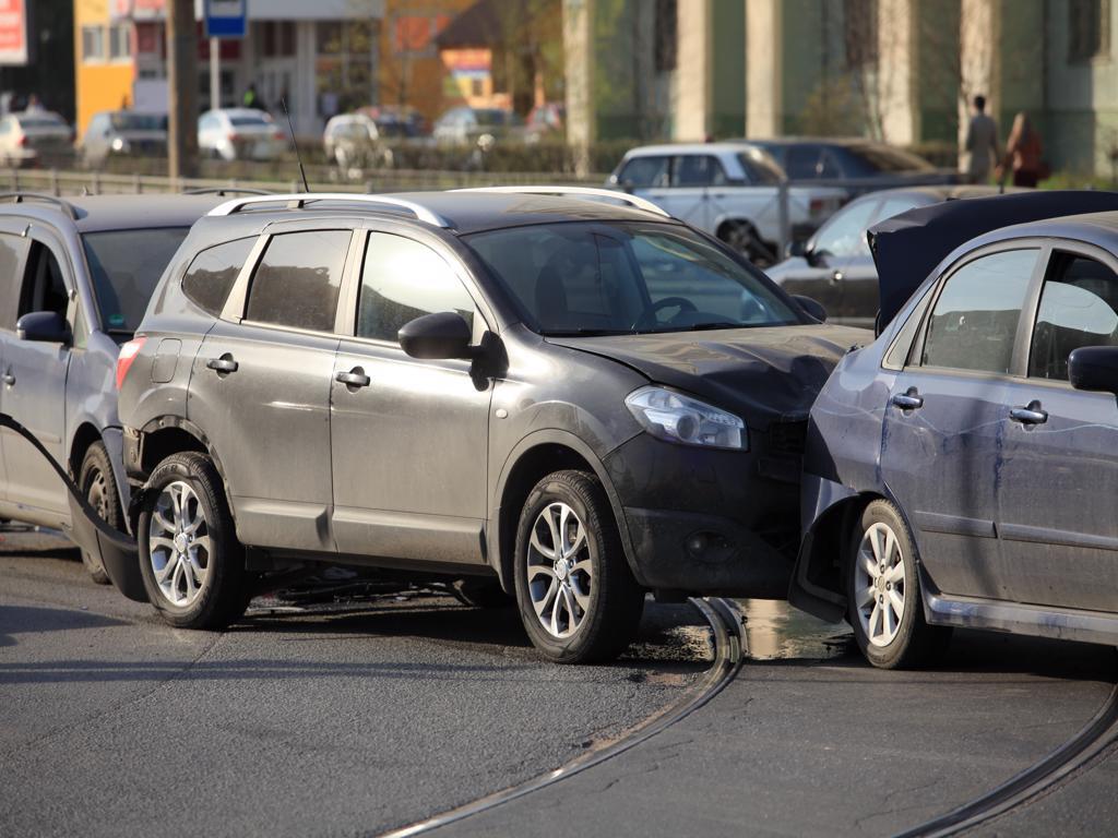 A group of cars are parked on the side of the road.
