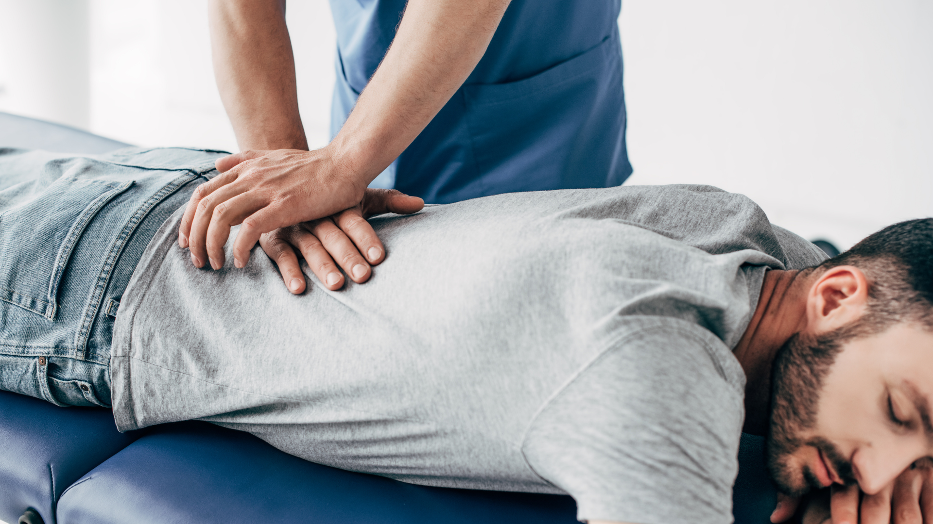a man is laying on a table getting a massage from a doctor .