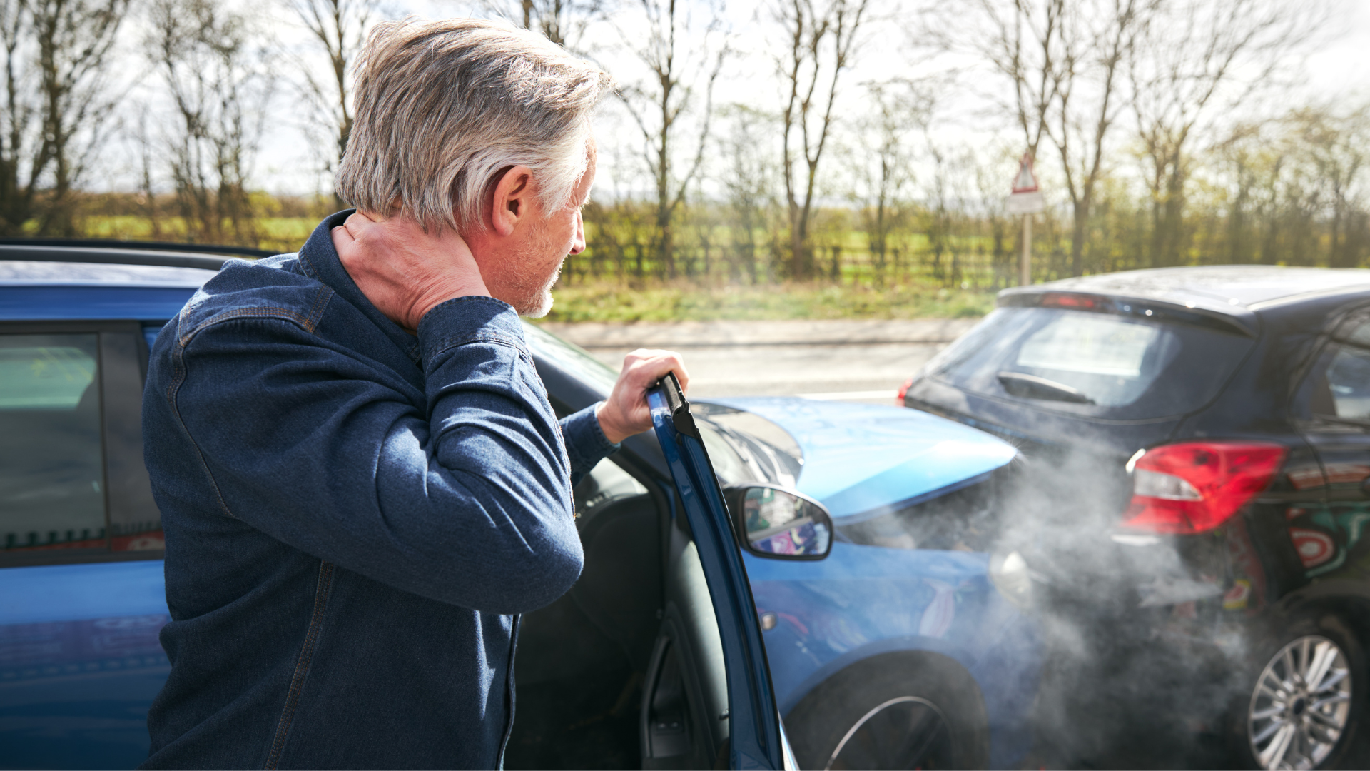 a man with a hearing aid is getting out of a car after a car accident .