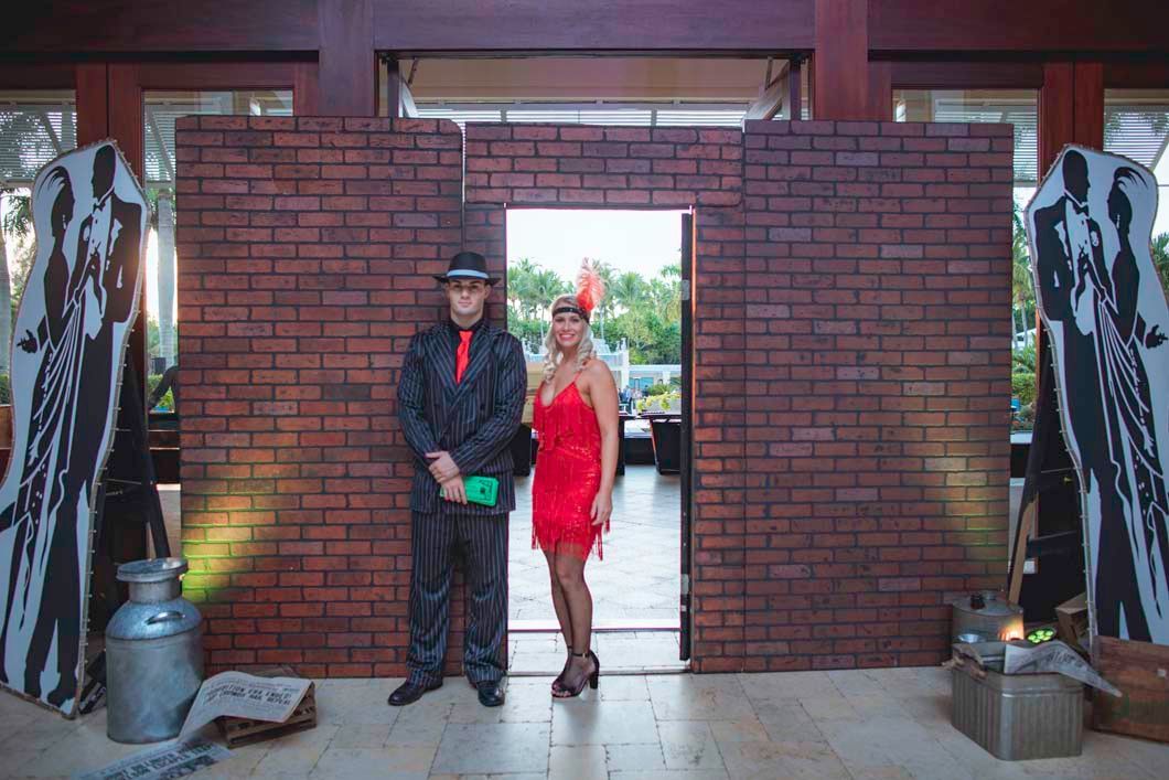 A man and a woman are standing in front of a brick wall.