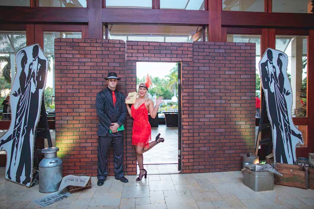 A man and a woman are standing in front of a brick wall.