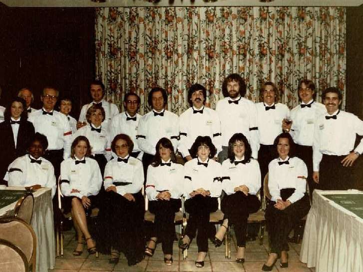 A group of people in tuxedos pose for a photo