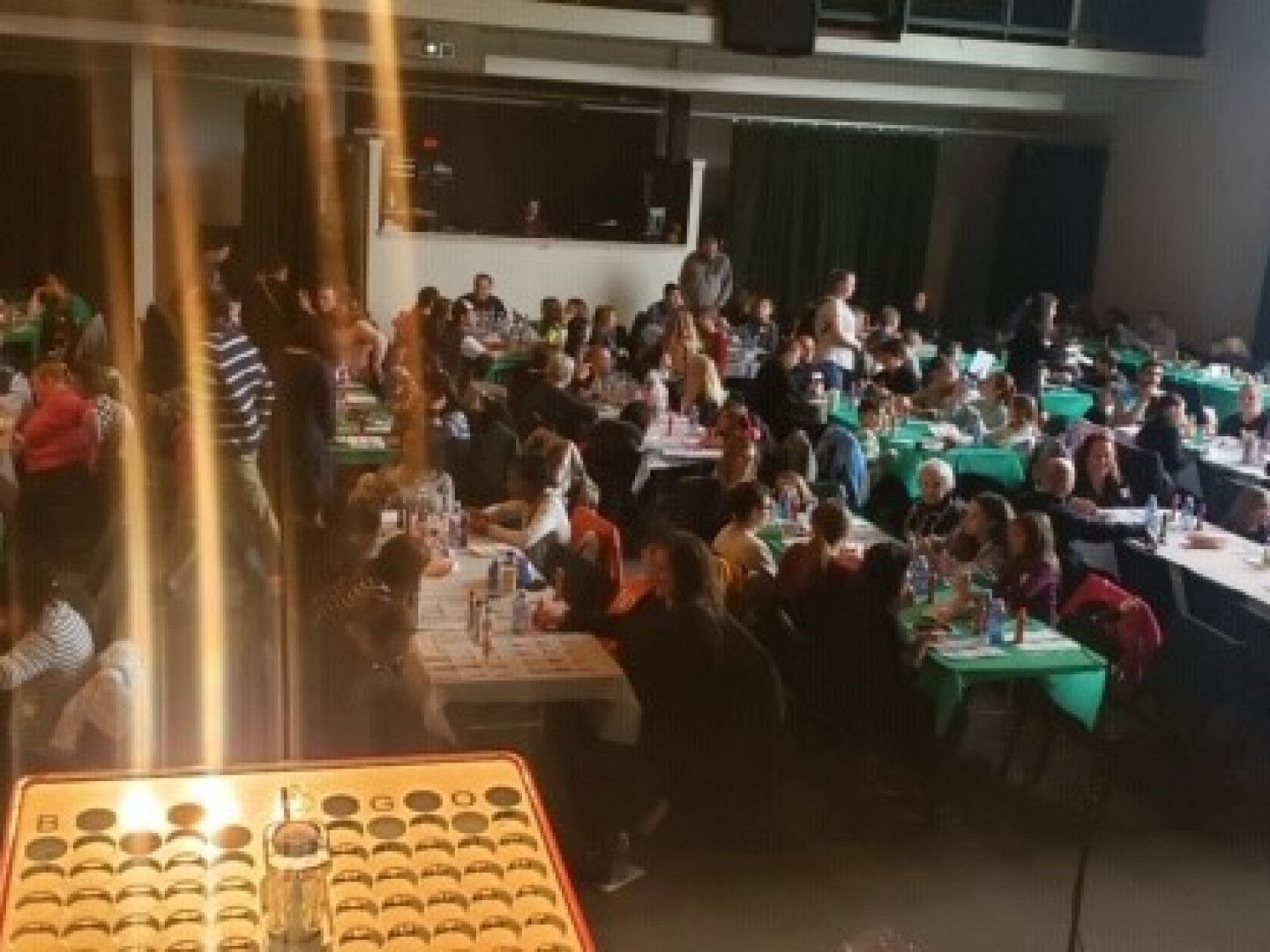 A large group of people are sitting at tables in a large room.