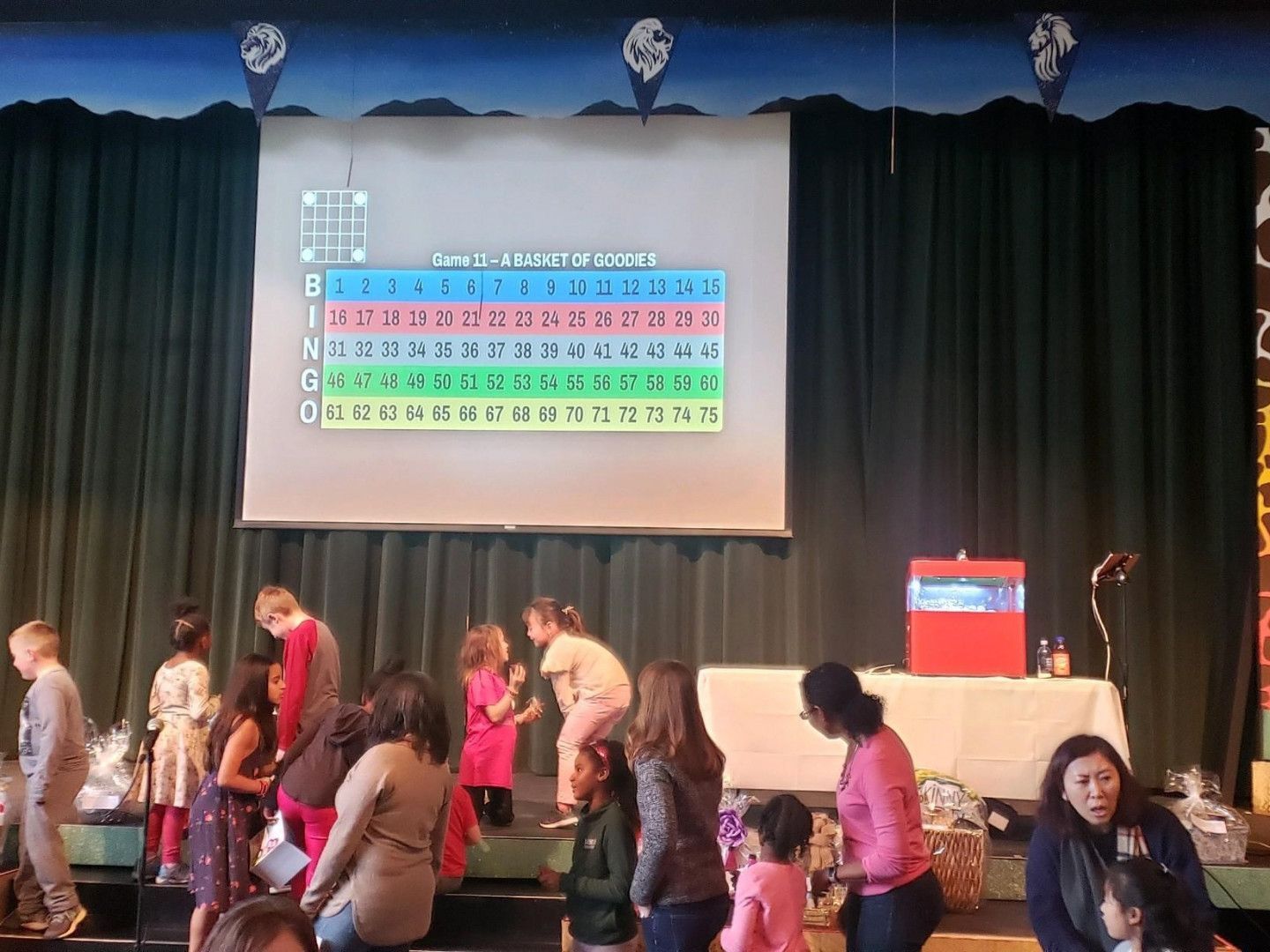 A group of people standing on a stage in front of a projector screen