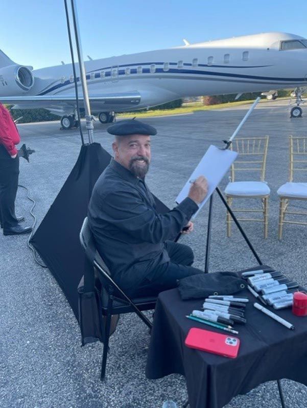 A man is sitting at a table in front of an airplane