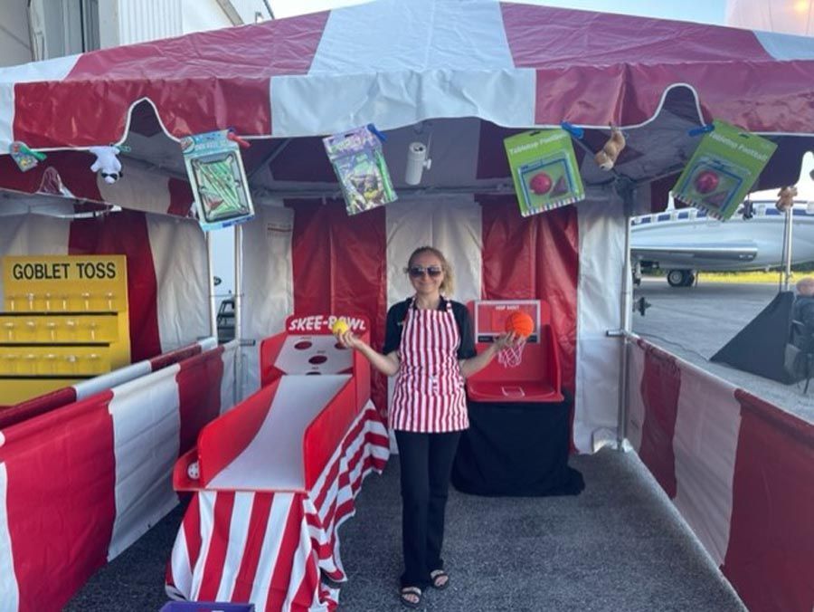 A woman is standing in front of a carnival game