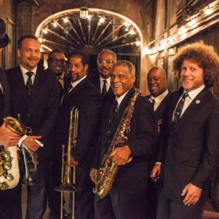 A group of men in suits and ties holding saxophones and trombones