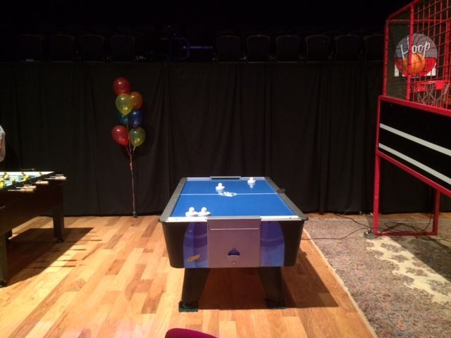 A blue air hockey table in a dark room