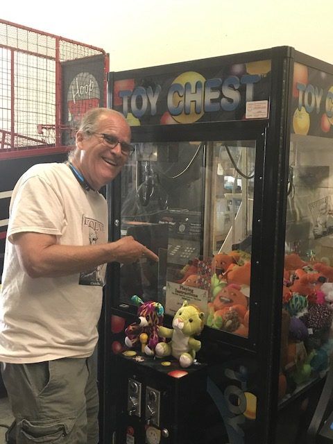 A man is standing in front of a toy chest