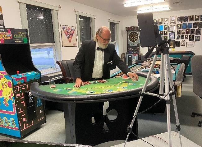 A man in a tuxedo is playing a game on a table.