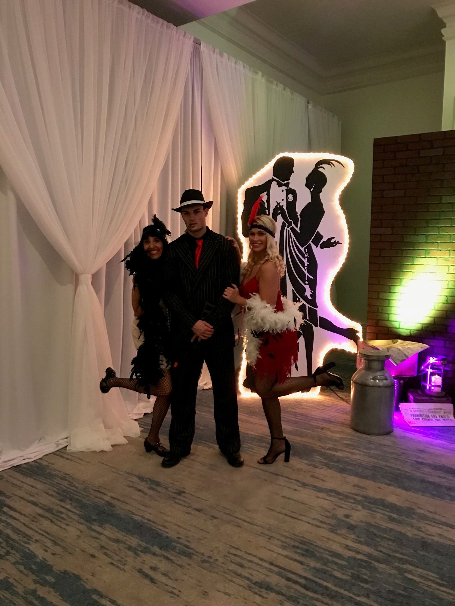 A man and two women are posing for a picture in a room.
