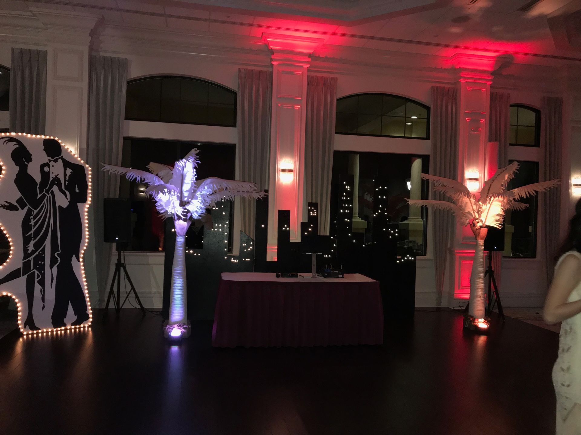 A woman is standing in a room with a silhouette of a man and woman dancing.