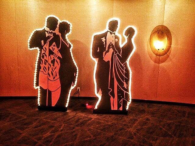 Two cardboard cutouts of a man and a woman dancing