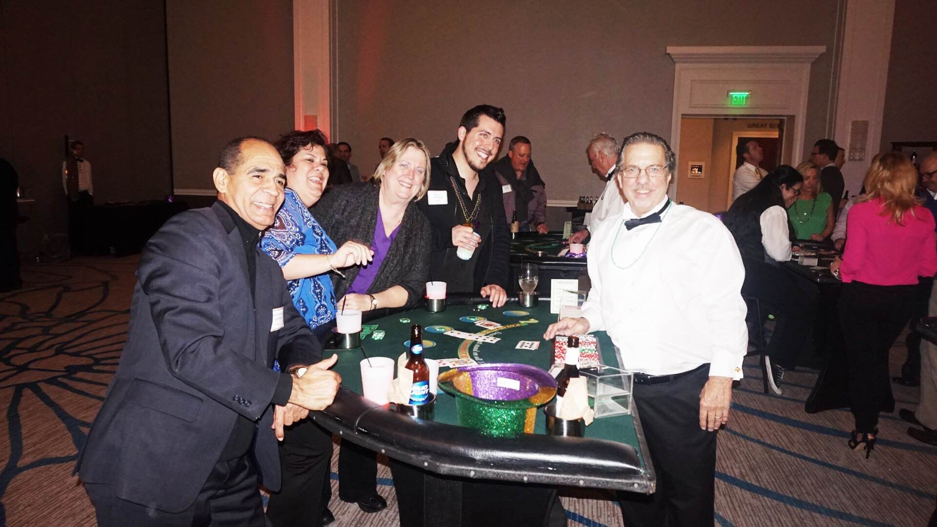 A group of people are standing around a roulette table.