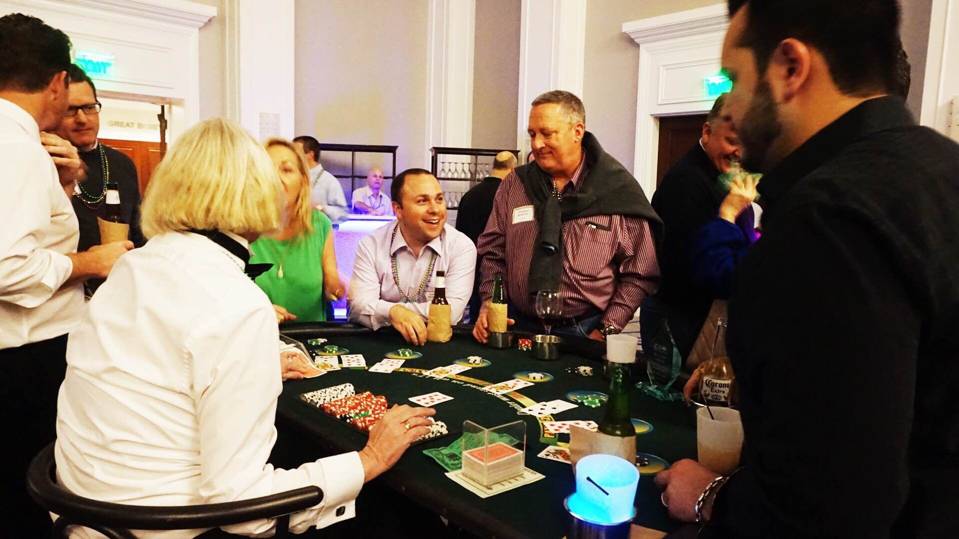 A group of people are sitting around a table playing cards.