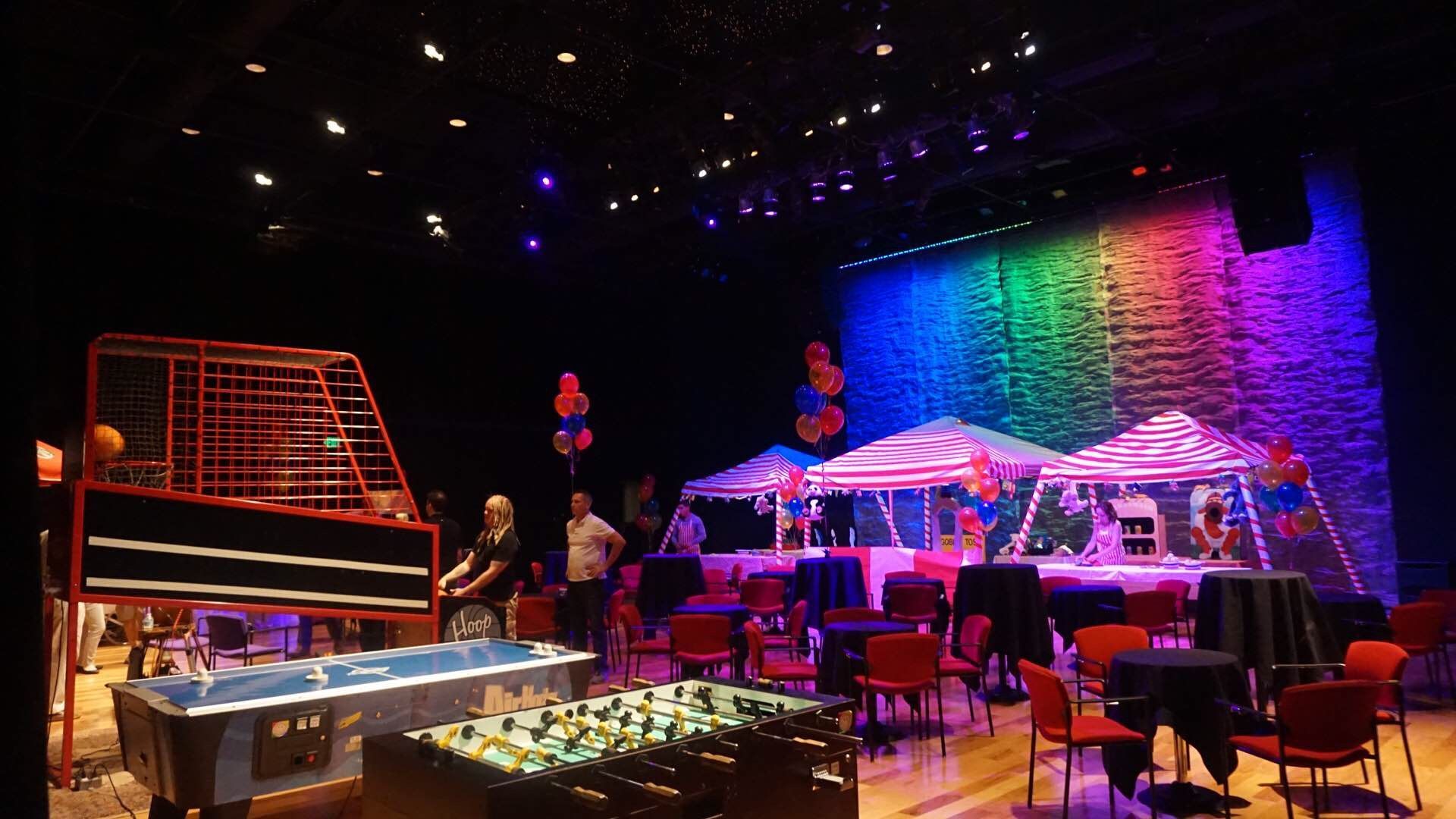 A large room with tables and chairs and a pool table