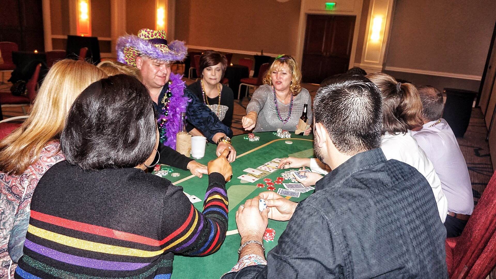 A group of people are sitting around a table playing cards.