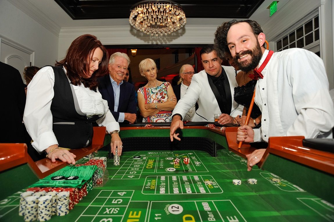 A group of people are playing roulette at a casino table.