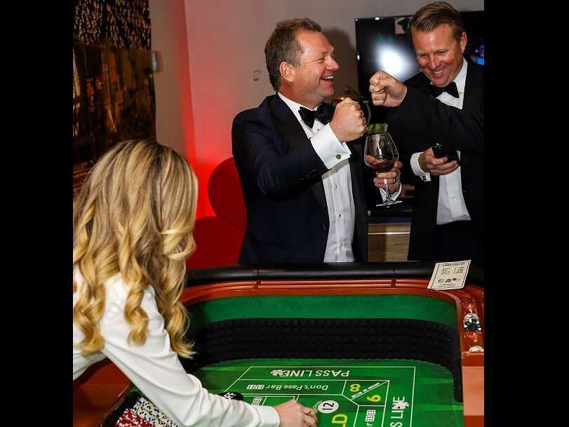 Two men and a woman are playing a game of roulette in a casino.