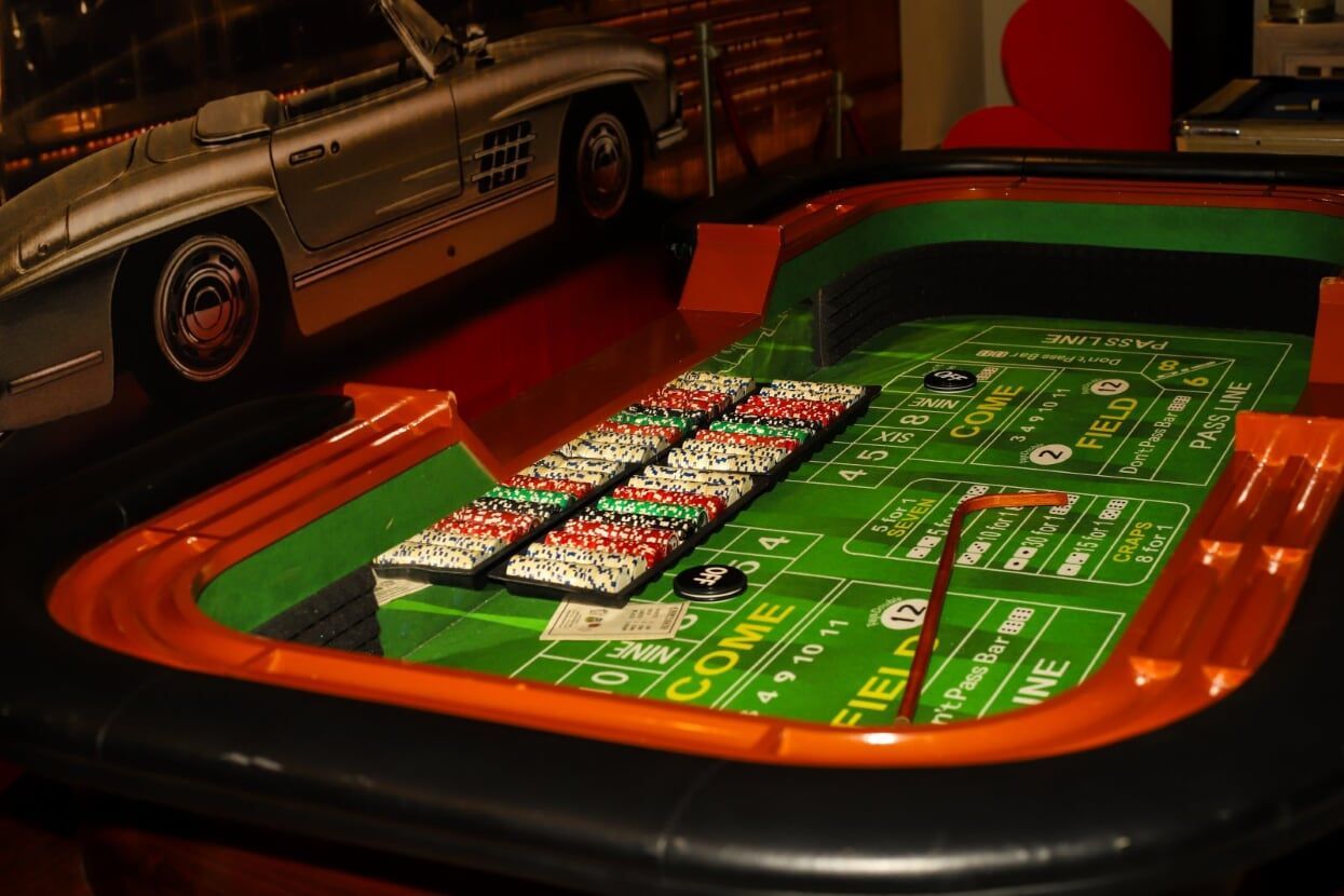 A roulette table with a silver car in the background