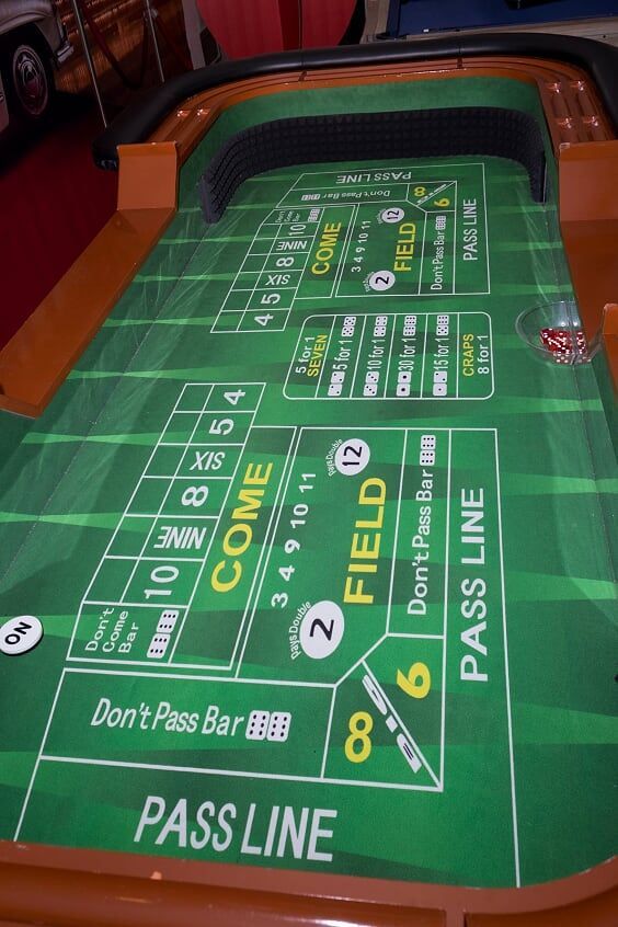 A green craps table with the words pass line on it