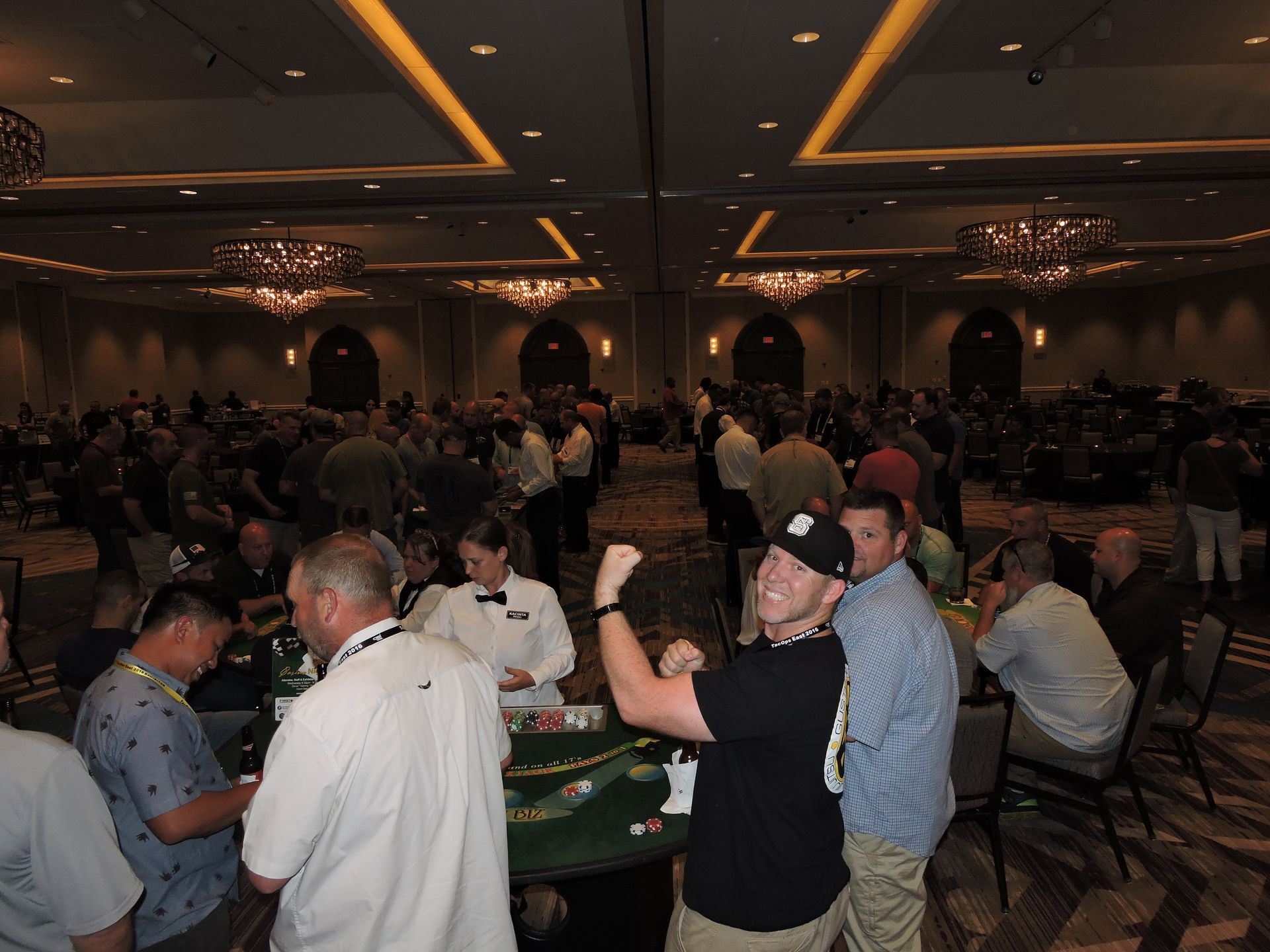 A group of people are playing poker in a large room.
