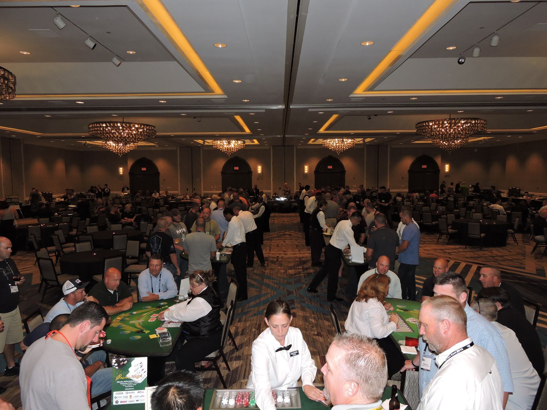 A large group of people are playing poker in a large room