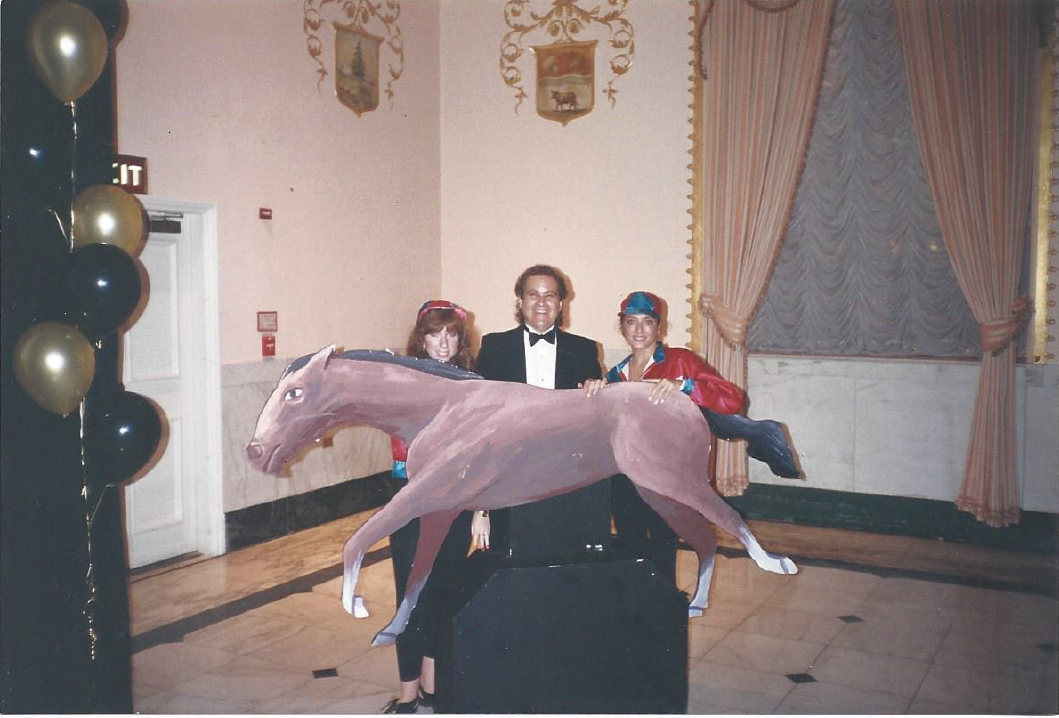 A group of people standing around a statue of a horse