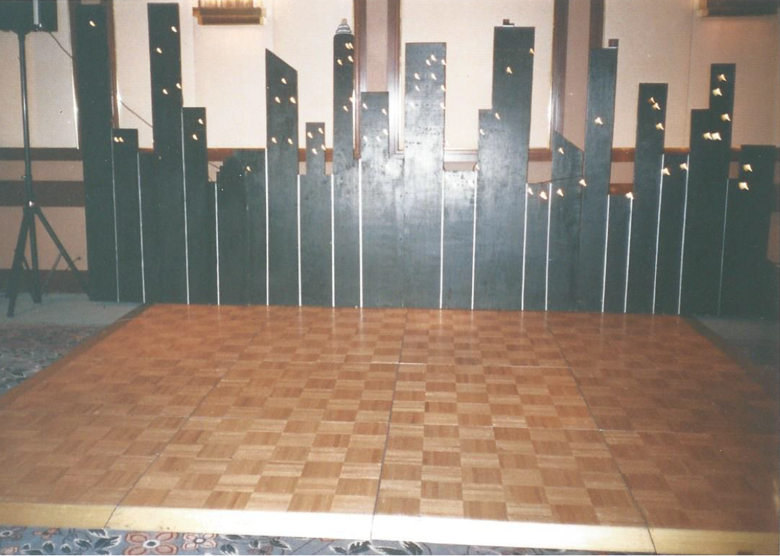 A wooden dance floor with a city skyline in the background