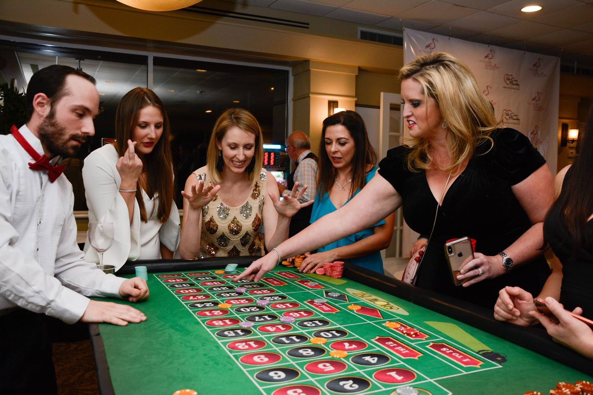 A group of people are playing roulette at a table.