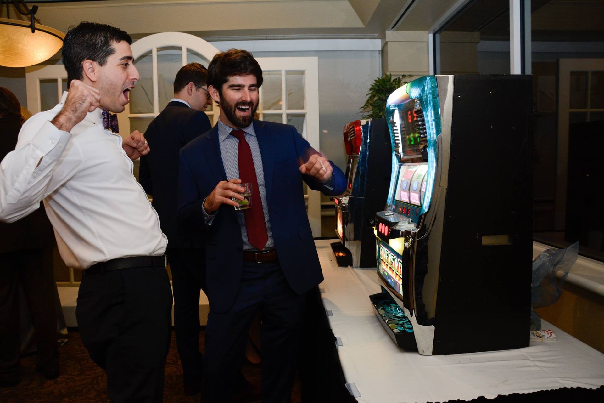 A group of men are standing around a slot machine.