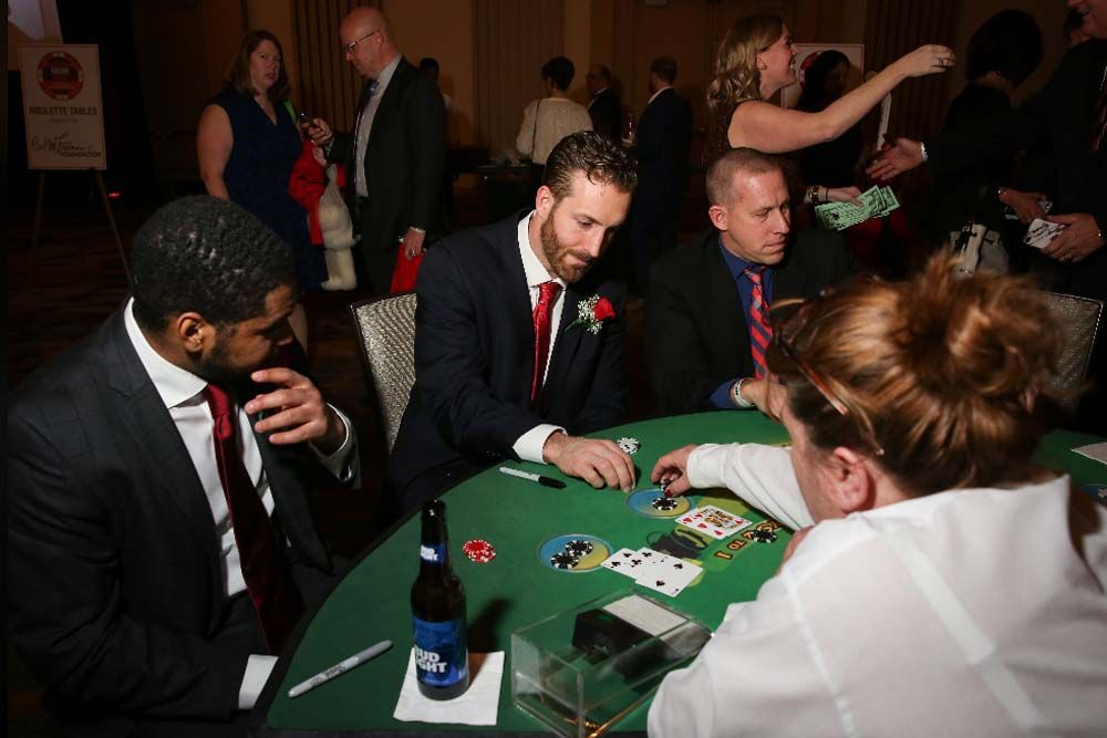 A group of people are sitting around a table playing poker.