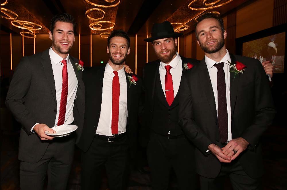 A group of men in suits and ties are posing for a picture.