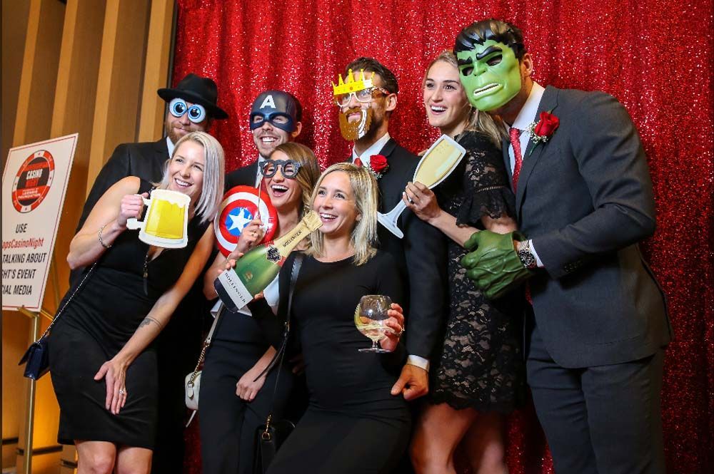 A group of people are posing for a picture in a photo booth.