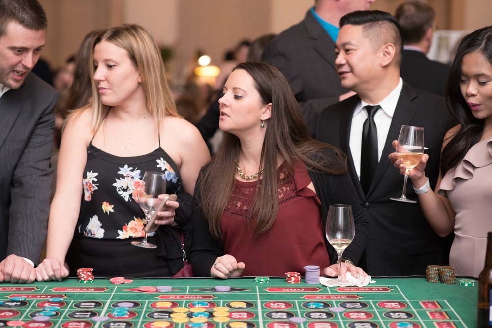 A group of people are playing roulette at a casino.