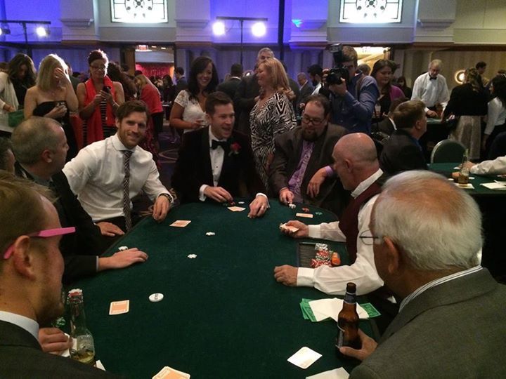 A group of people are sitting around a table playing poker