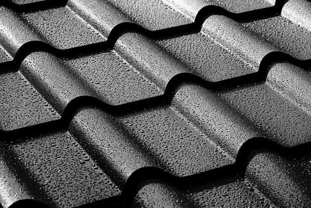 Black roof tiles with a textured, wavy pattern in close-up