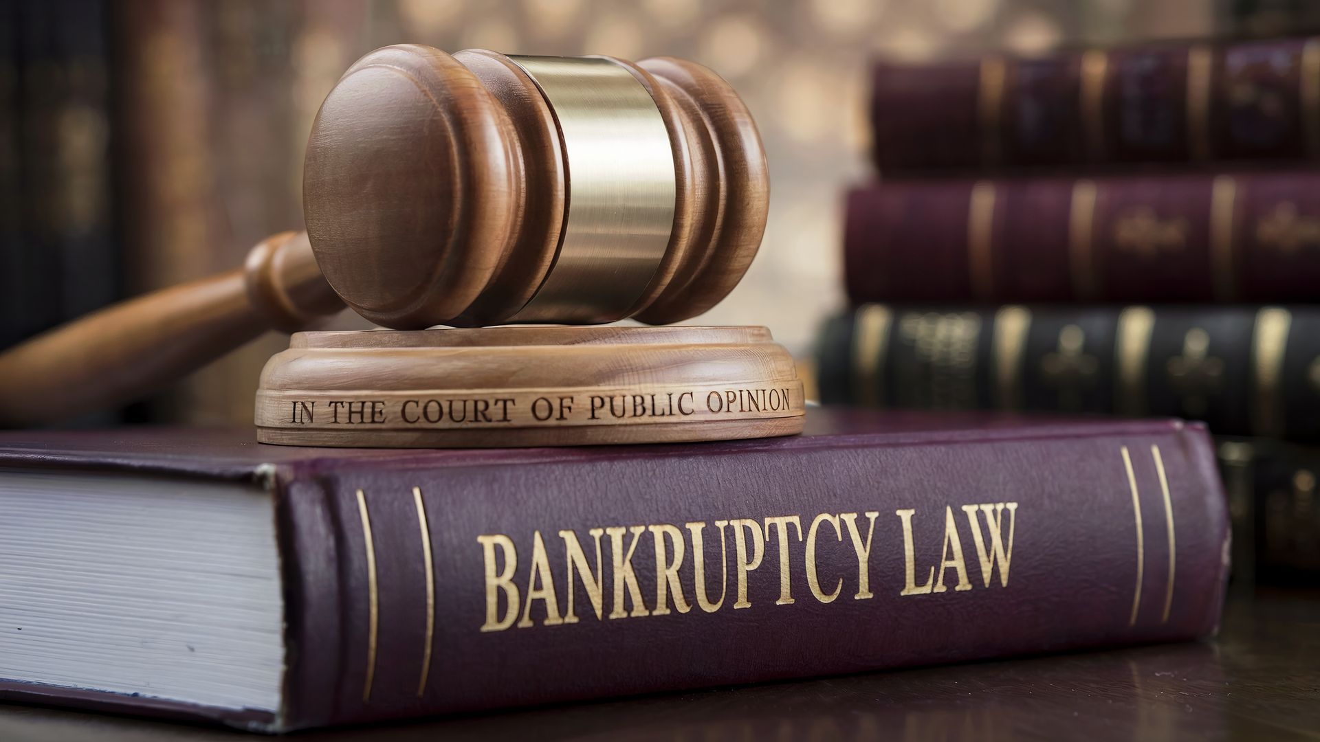 Judge's gavel on bankruptcy law book with legal books in background. Judge's gavel on bankruptcy law book with legal books in background.