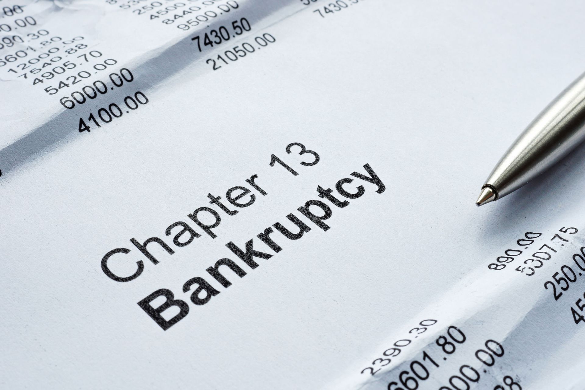 Chapter 13 Bankruptcy form with financial papers and a pen. Chapter 13 Bankruptcy form with financial papers and a pen.