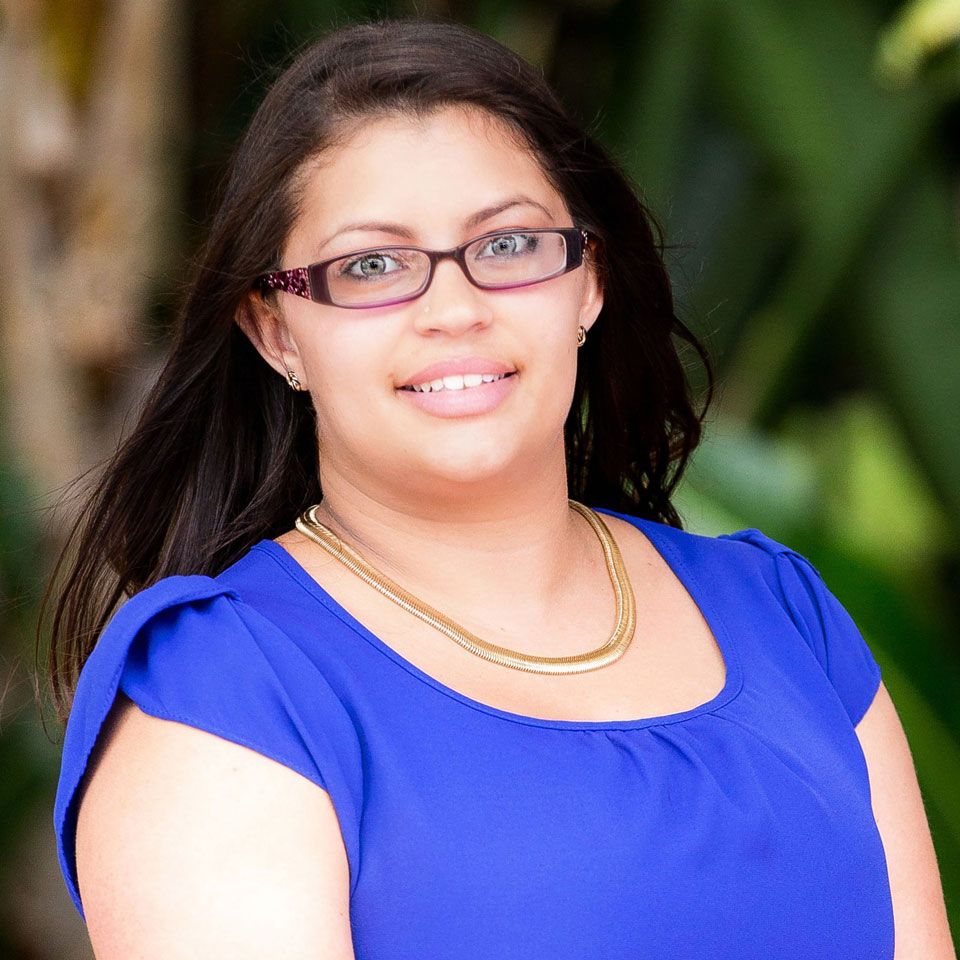 Veronica Wallach Portrait of a smiling woman in a bright blue top and glasses outdoors