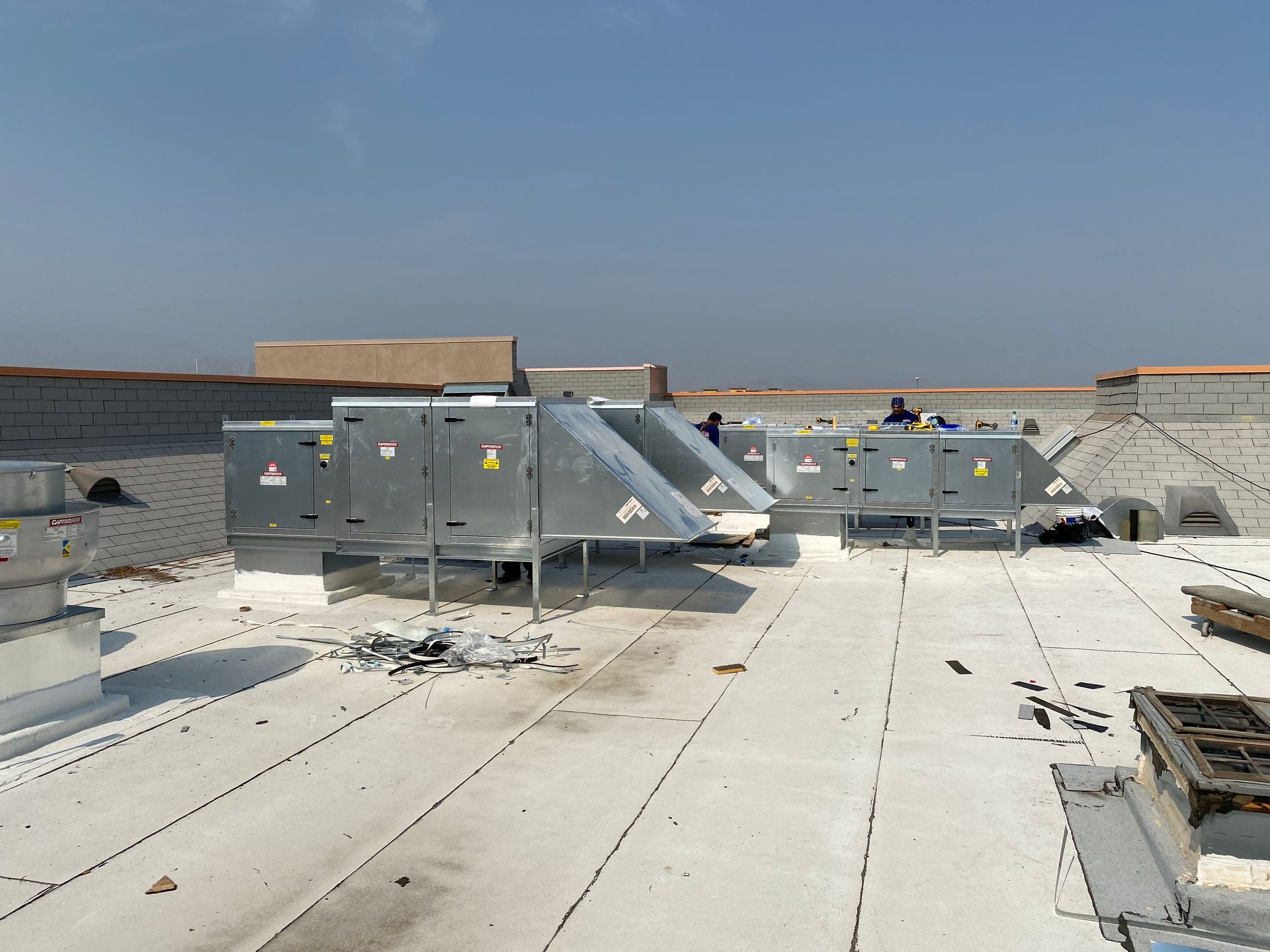 HVAC units on a flat rooftop under a clear blue sky.