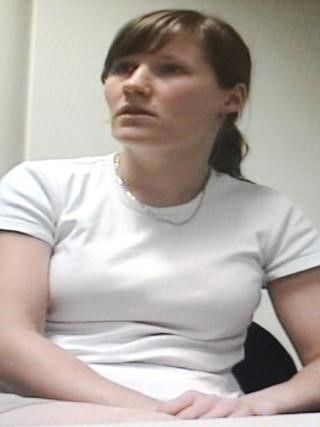 Woman with brown hair sitting in a white T'Shirt