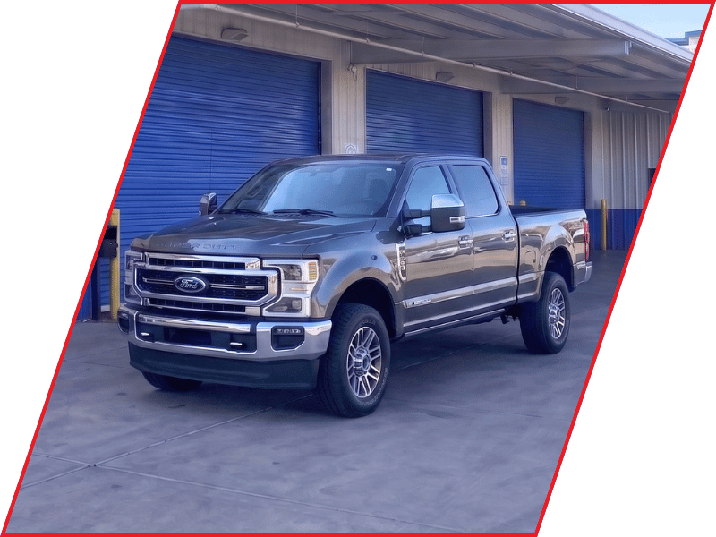 Gray Ford Super Duty pickup truck parked outside an automotive service facility