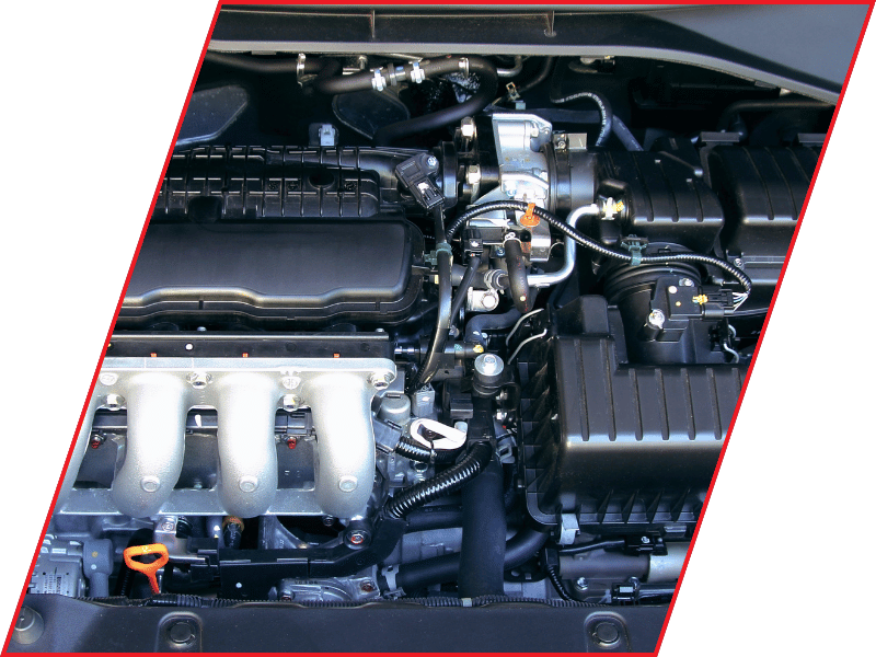 Close-up view of a vehicle engine with intake components, hoses, wiring, and fluid reservoirs