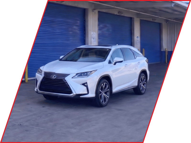 White Lexus RX luxury SUV parked outside an automotive service facility with blue garage doors