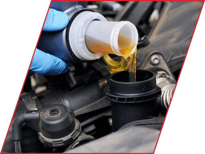 Automotive fluid being poured into a reservoir inside a vehicle engine compartment