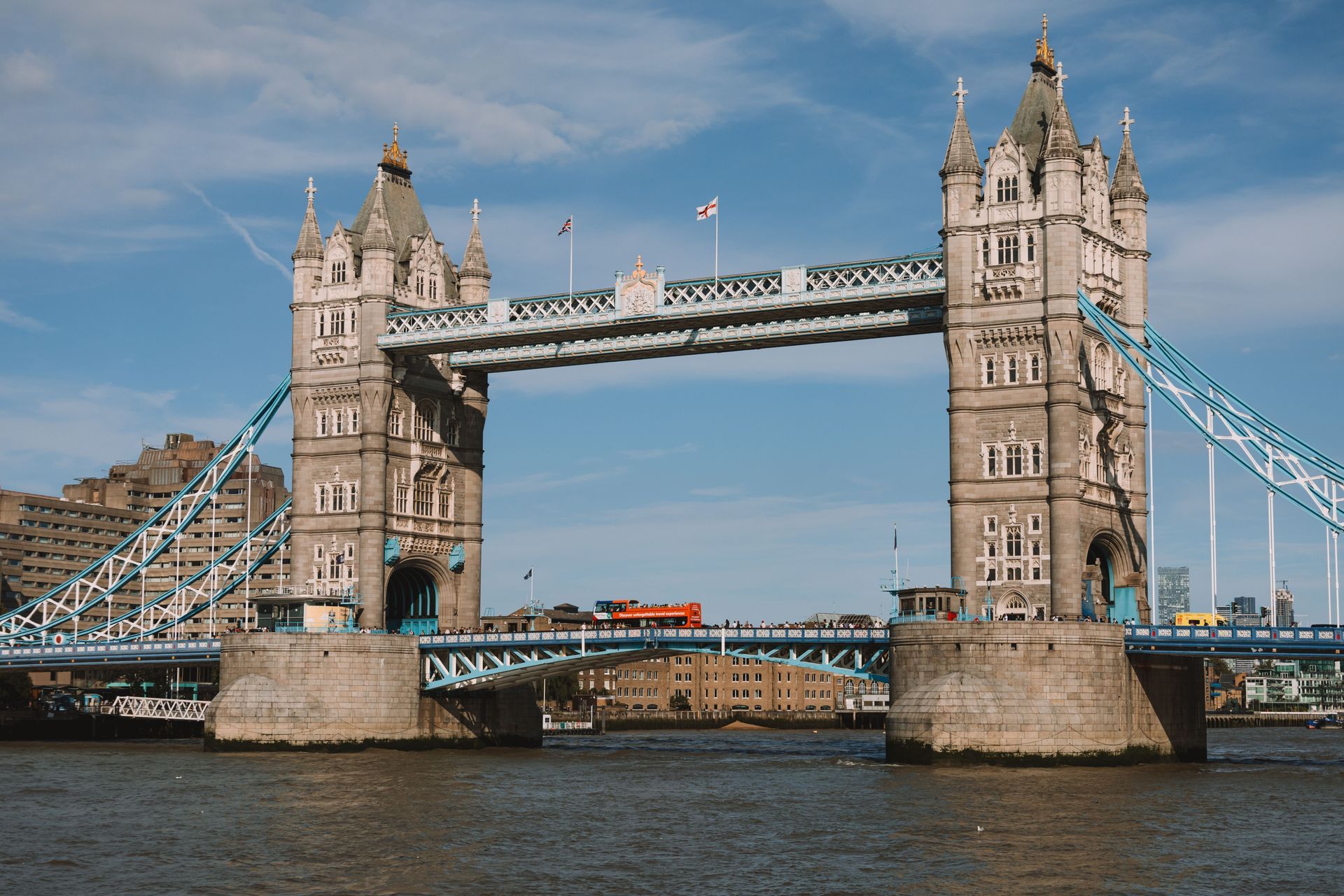 Tower Bridge over the River Thames in London, with blue suspension elements and a boat passing below