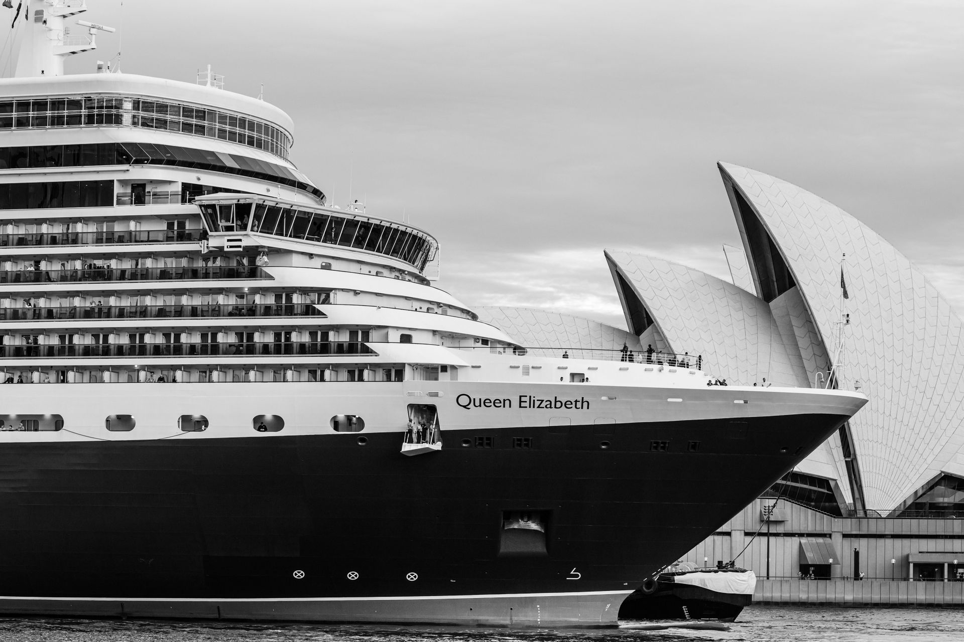 Black-and-white view of a cruise ship docked near the Sydney Opera House