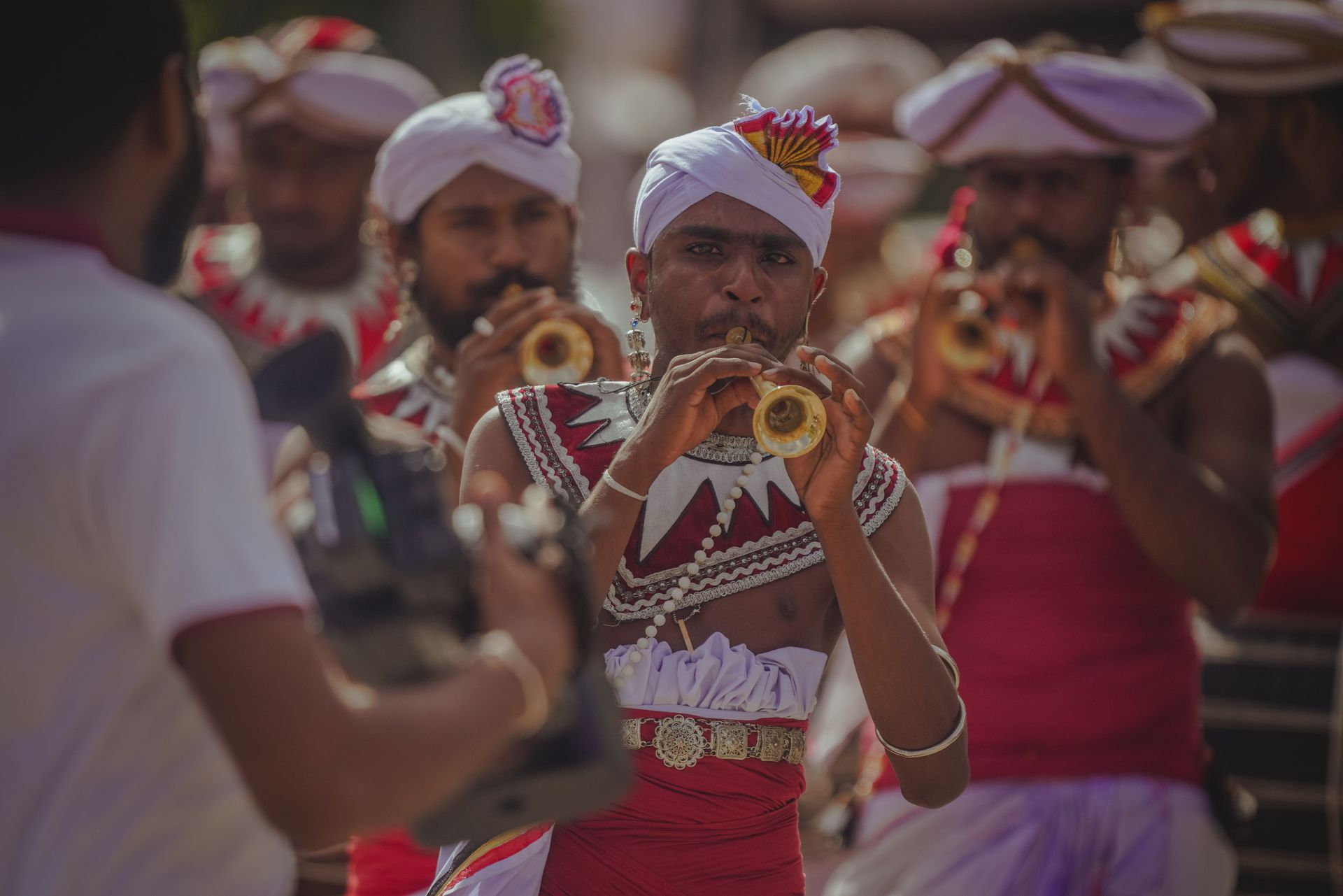 Photorealistic Sri Lankan cultural procession with lanterns, traditional clothing and warm evening light