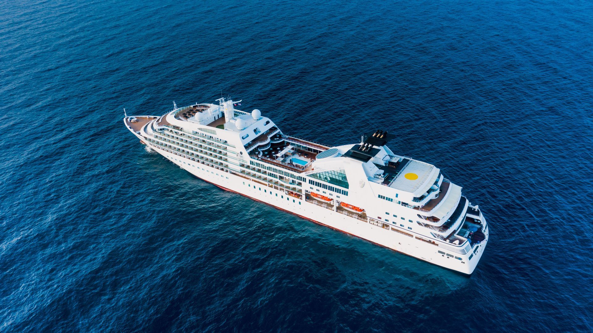White cruise ship sailing on deep blue ocean